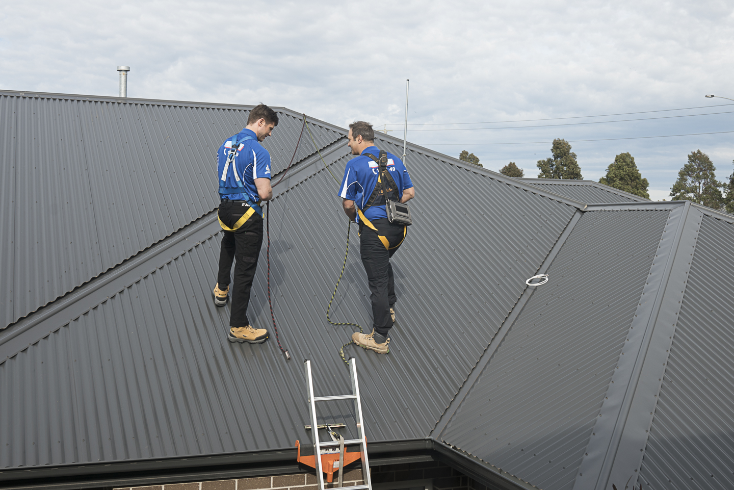 Two professional technicians installing a digital TV antenna on a rooftop in Australia to improve reception and replace outdated analogue aerials.