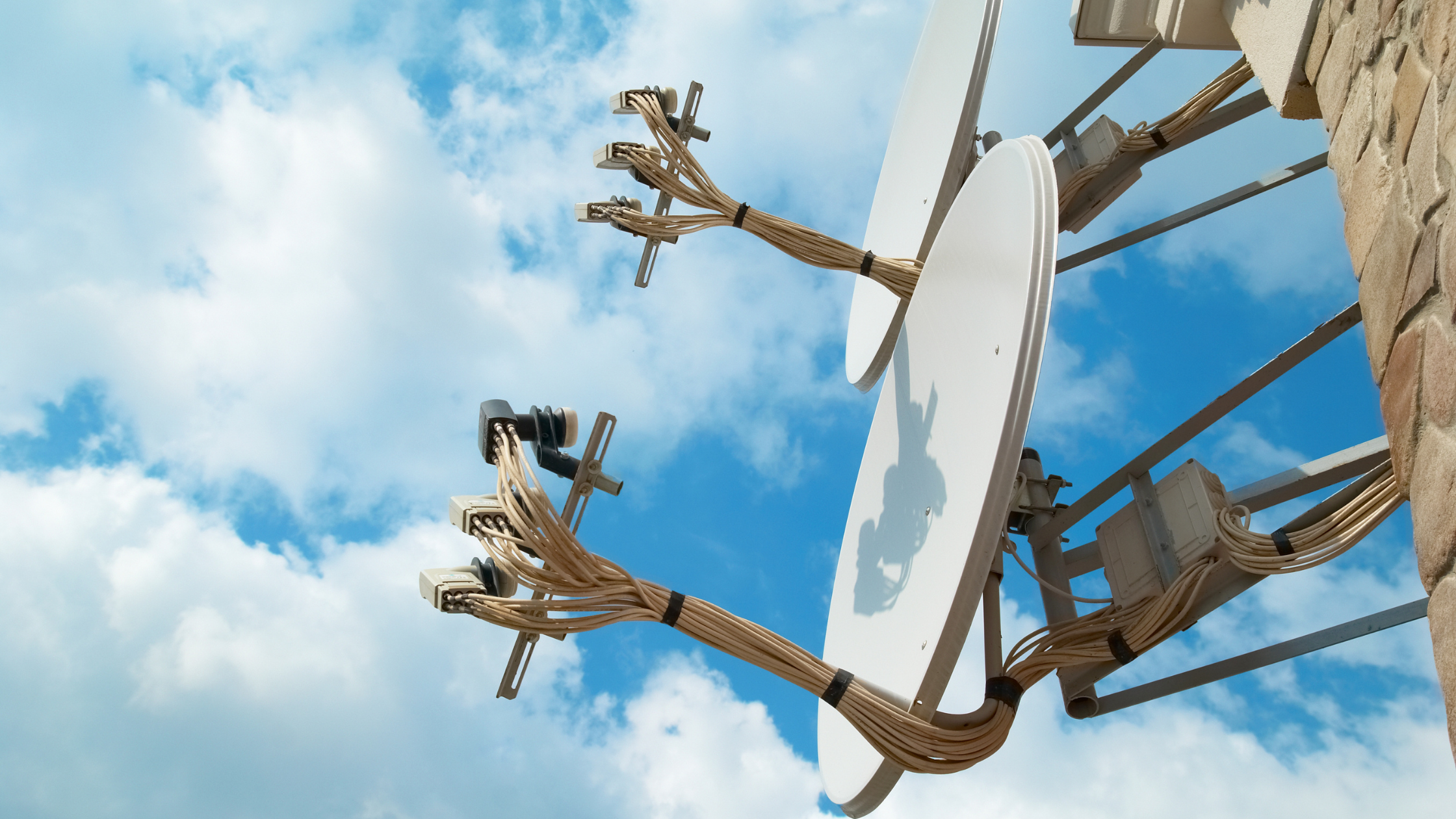 Outdoor satellite antenna with cabling installed on a residential building for TV signal reception