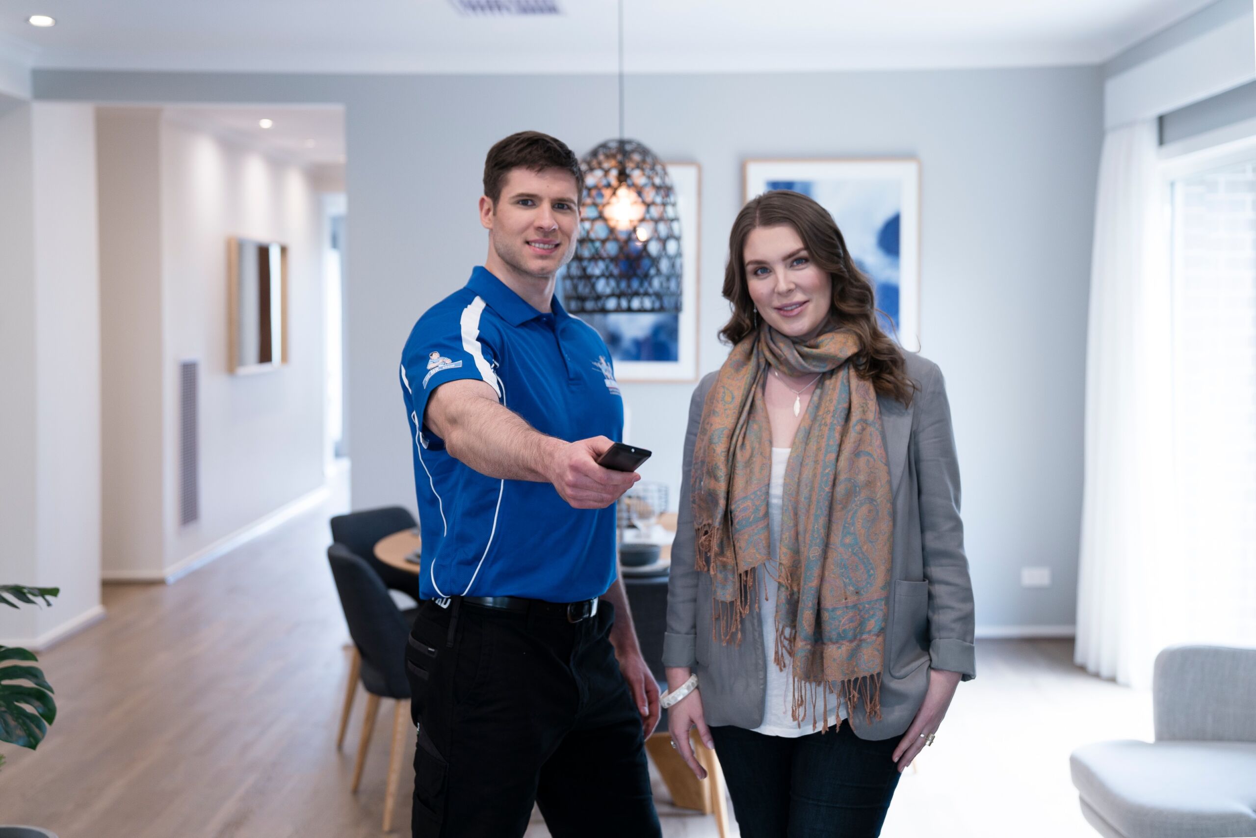 Mr Antenna technician assisting a customer inside her Adelaide home while demonstrating TV reception, representing professional support for correct Adelaide antenna direction.