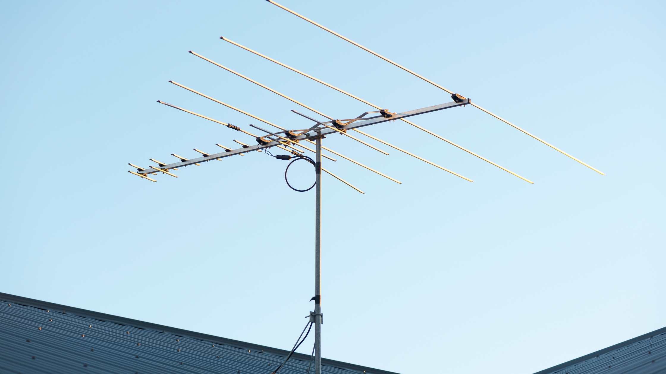 Rooftop TV antenna mounted on metal roof representing tv reception problems after repair and recurring antenna issues