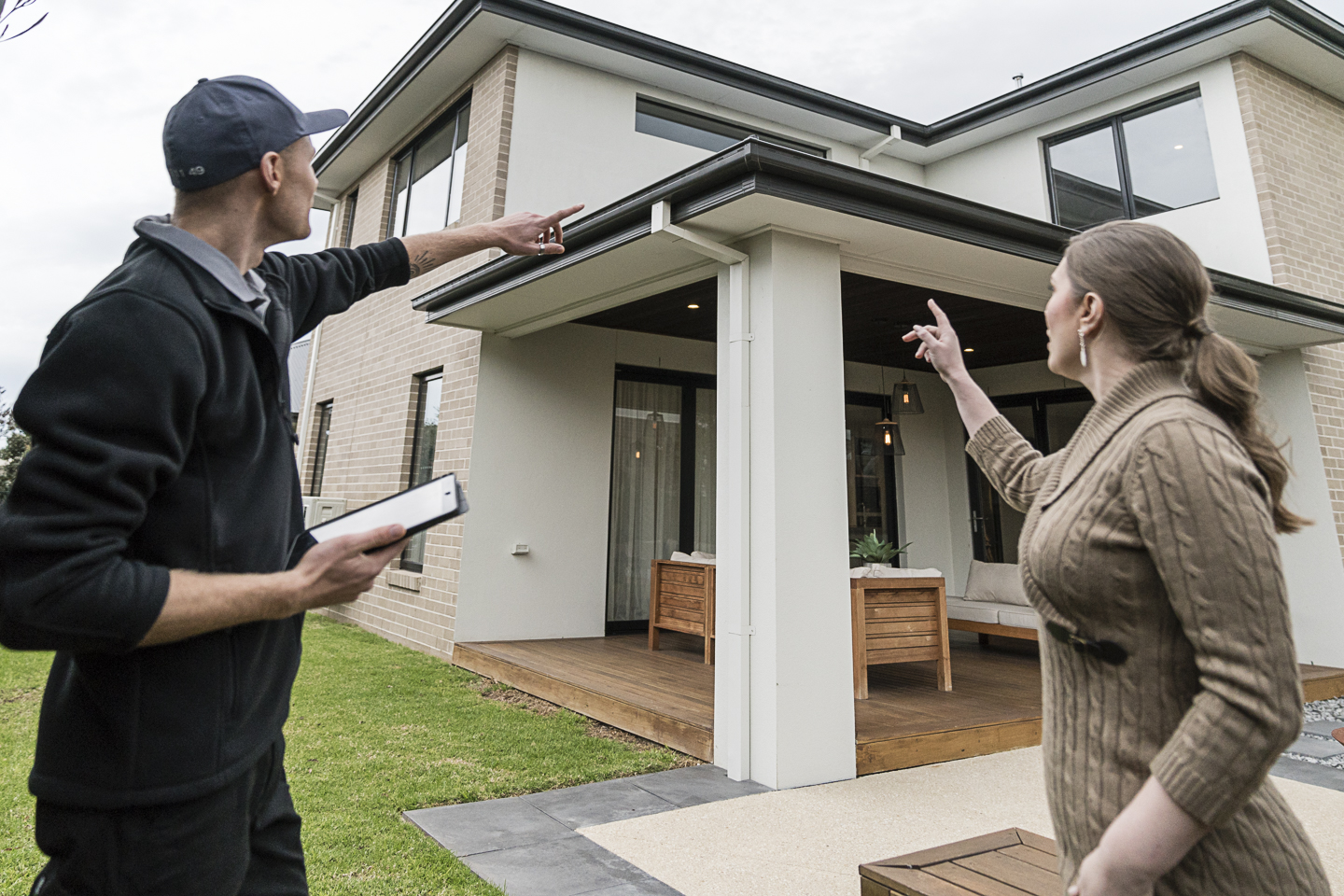 Homeowner inspecting roof gutters during end of summer maintenance in Australia