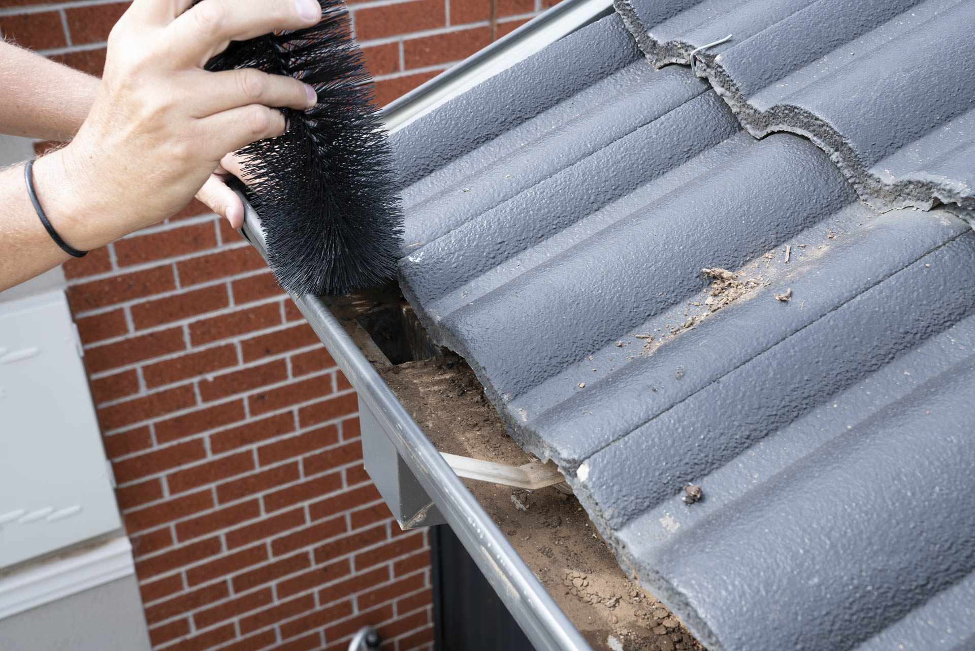 Close-up of gutter guard installation on a tiled roof, preventing leaves, dirt, and debris from blocking Australian home gutters.
