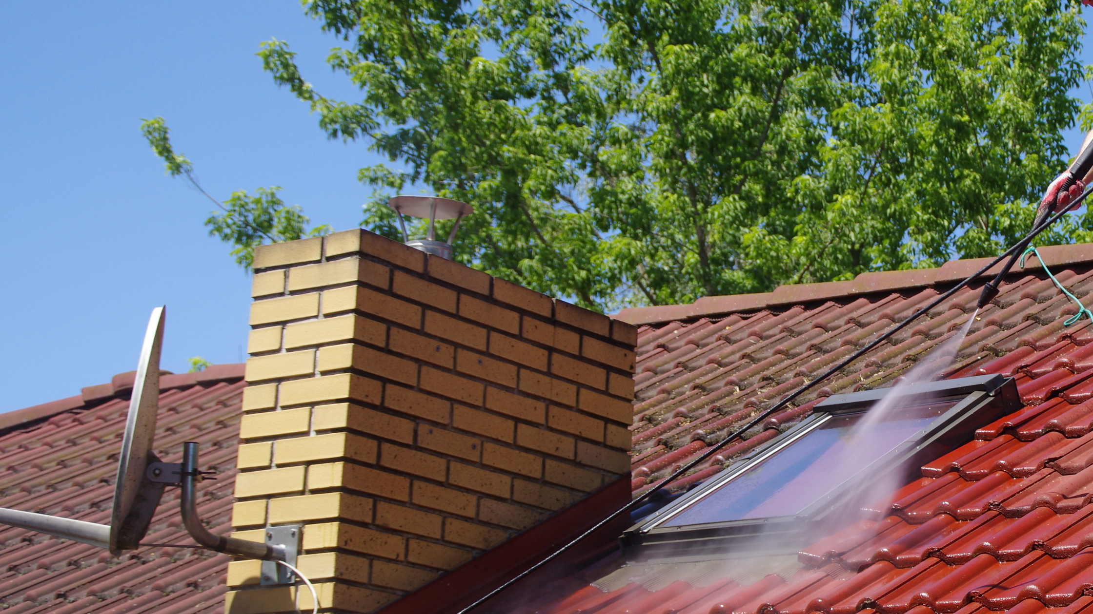High pressure roof cleaning removing moss and debris to prevent pest infestations