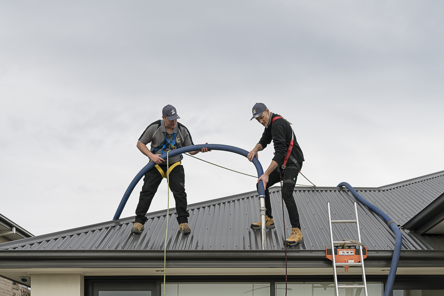 Professional gutter cleaning service removing debris from a residential roof to prevent water damage
