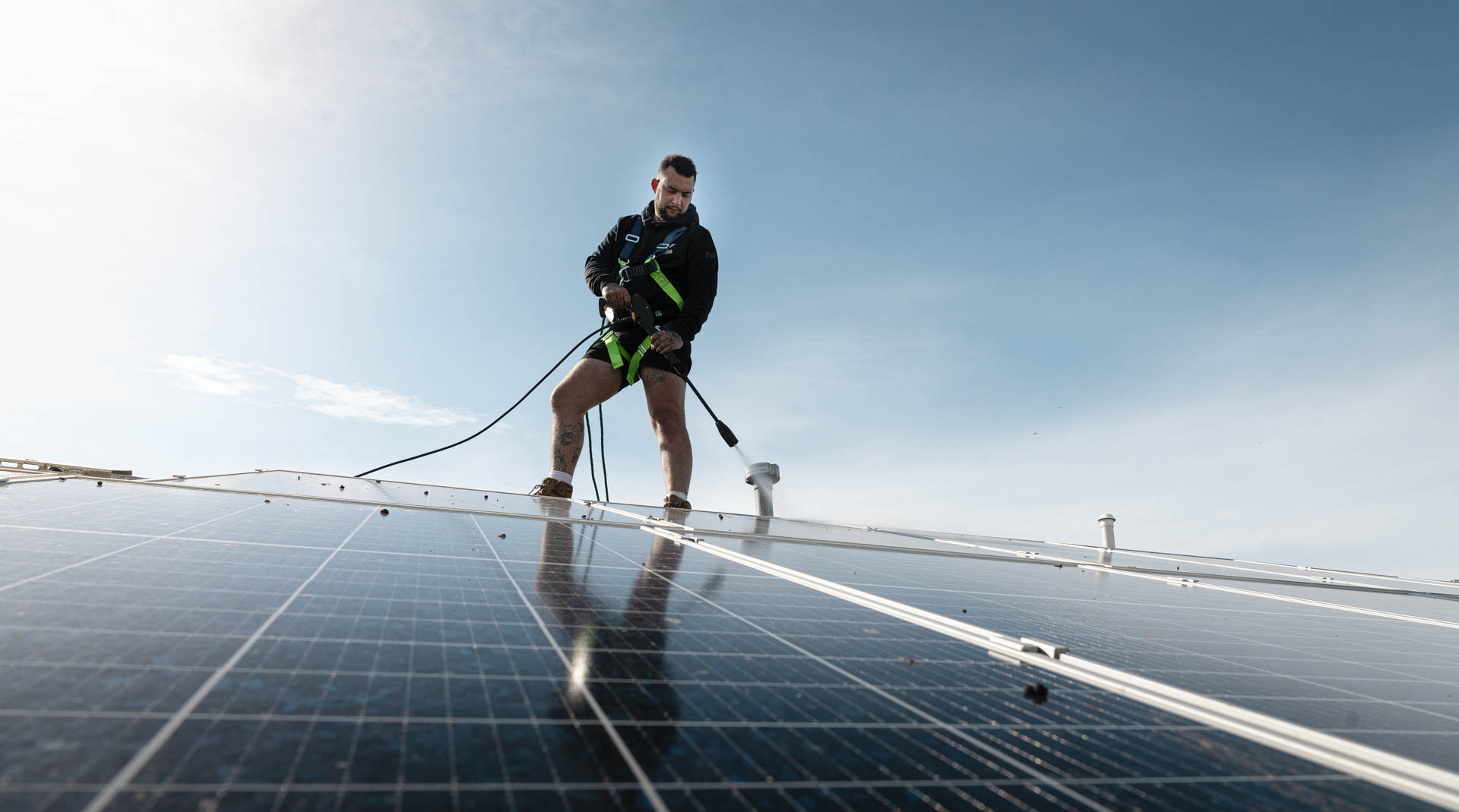 Professional solar panel cleaning on rooftop to improve efficiency and reduce electricity bills