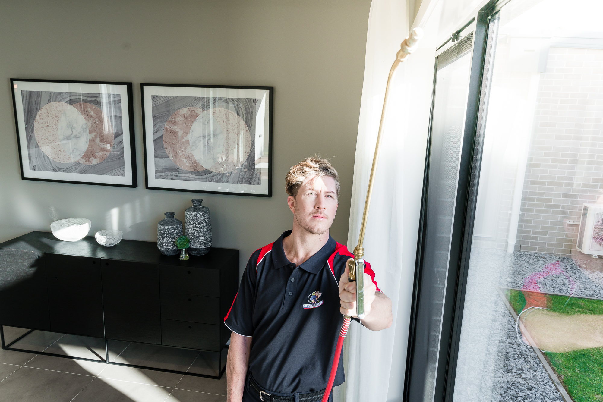 Professional pest inspector examining a home interior with spraying equipment during a thorough residential pest inspection.
